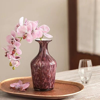 Marbled purple glass vase with pink orchid for home decor