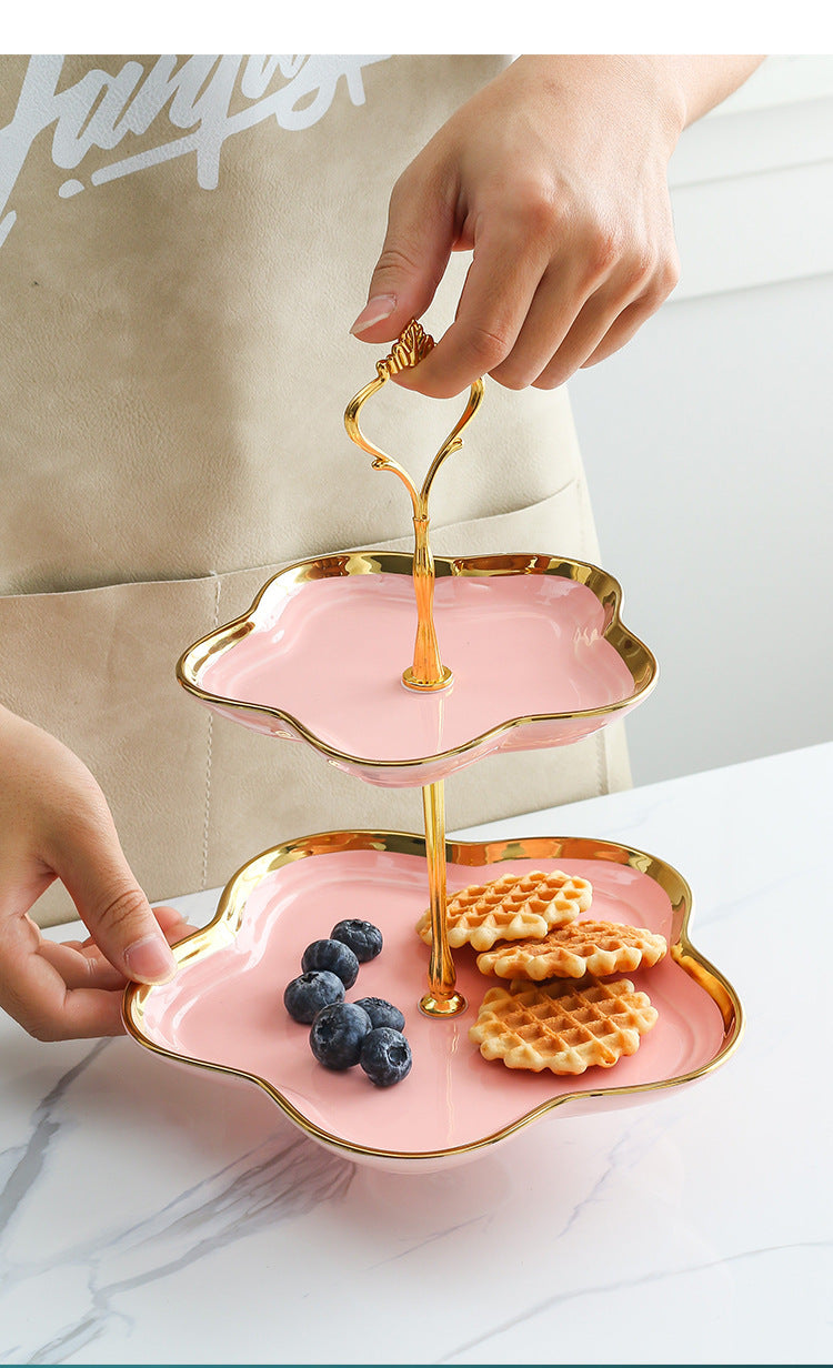 Pink ceramic two-tier dessert stand with handle, ideal for fruit, cookies, and afternoon tea