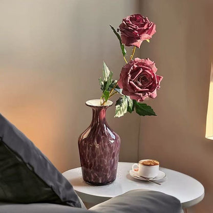 Purple glass flower vase with roses and coffee table setup