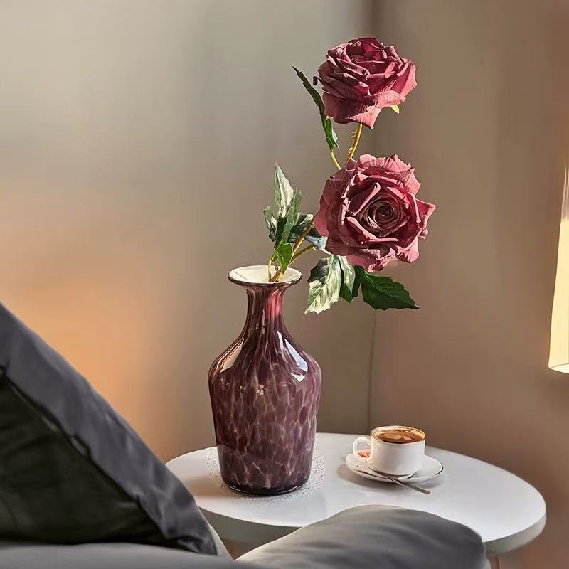 Purple glass flower vase with roses and coffee table setup